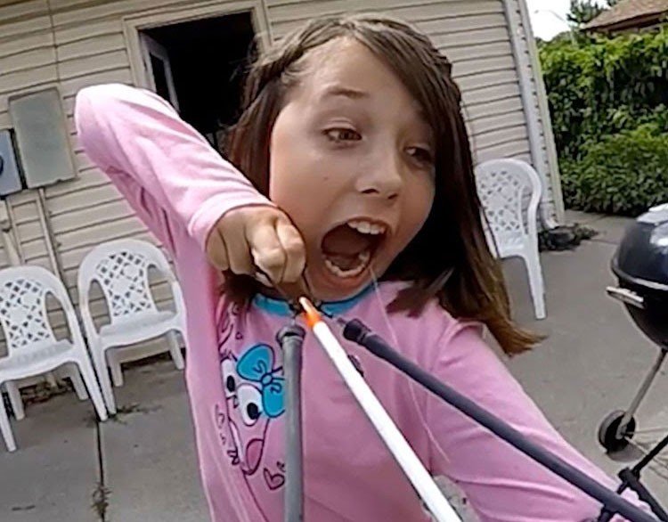 Niña ata su diente a una flecha