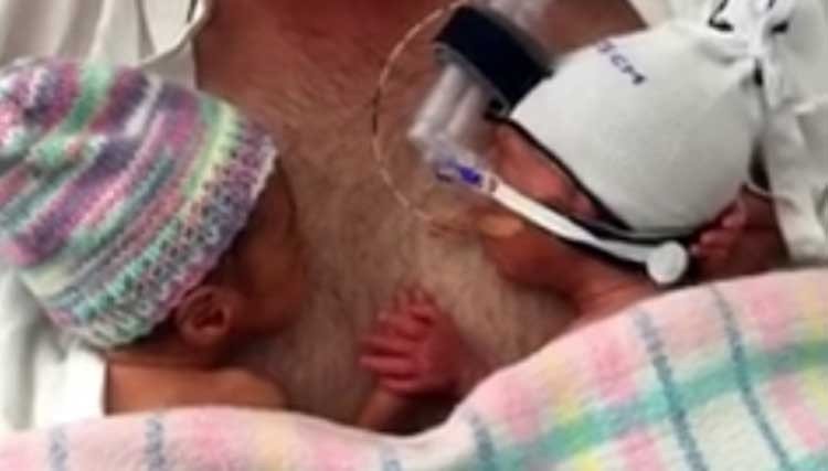 Pequeños gemelos recién nacidos de la mano